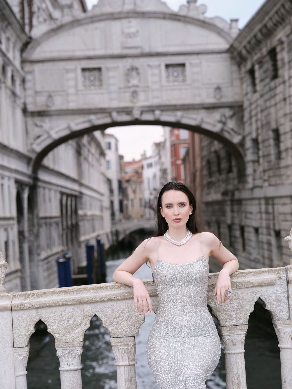 Elegant silver sequined gown sparkles against the iconic Bridge of Sighs in Venice, Italy.