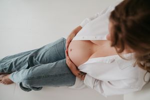 Zwangerschapsfotoshoot blote buik in daglicht studio M te Moerbeke. Melissa Stuer Moederschapsfotograaf  fotograaf jeans en wit hemd detail