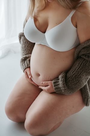 Zwangerschapsfotoshoot detail blote buik lingerie in daglicht studio M te Moerbeke. Melissa Stuer Moederschapsfotograaf  fotograaf