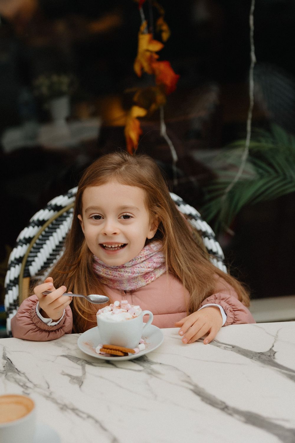 A sequence of images showing someone playfully hiding behind a white marble table while eating a snack.