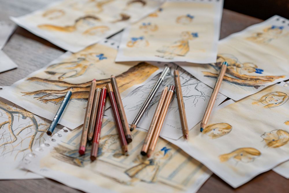 Gros plan sur les dessins et crayons d'une illustratrice