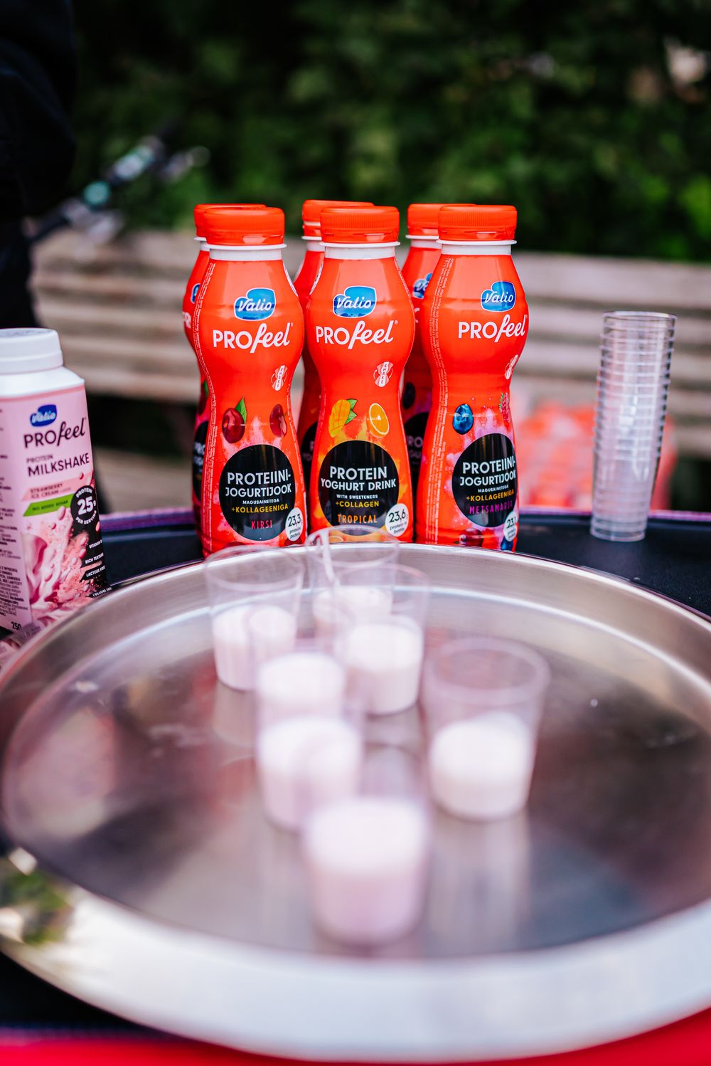 Red protein drink bottles displayed with ice cubes in a metal tray for refreshing summer beverages.