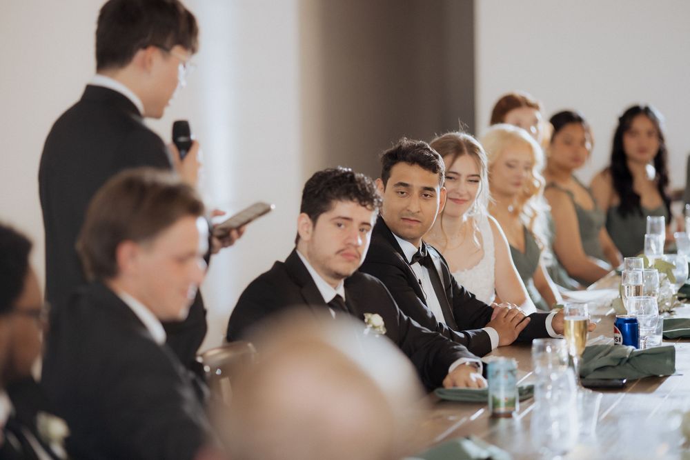 Business professionals seated at long conference tables during a corporate meeting or seminar presentation.