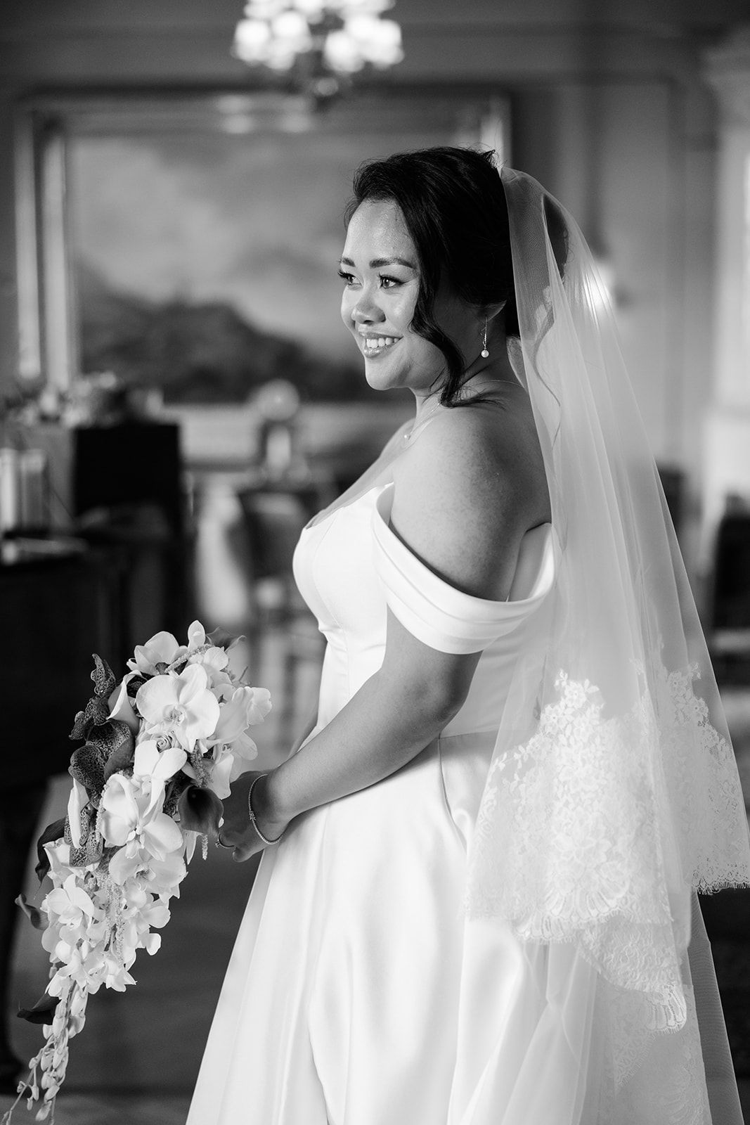 Black and white wedding photography series showing elegant bride in white dress with cascading orchid bouquet.