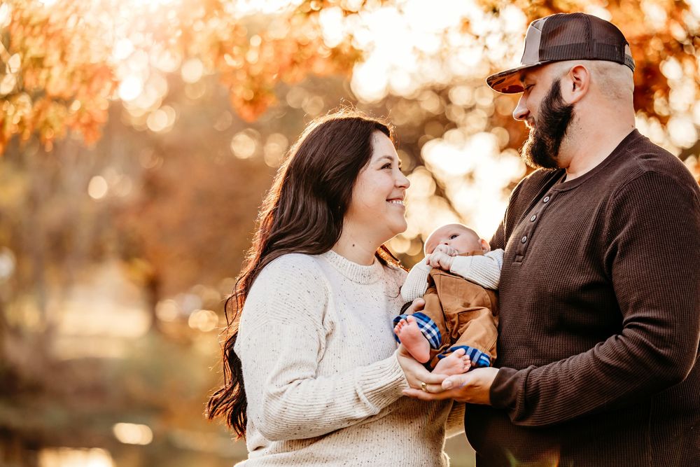 Romantic outdoor photoshoot with warm fall colors and bokeh lighting effects in the background.
