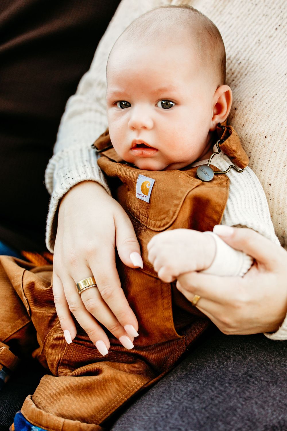 A sequence of photos showing a baby in a brown leather jacket being held against a light-colored background.