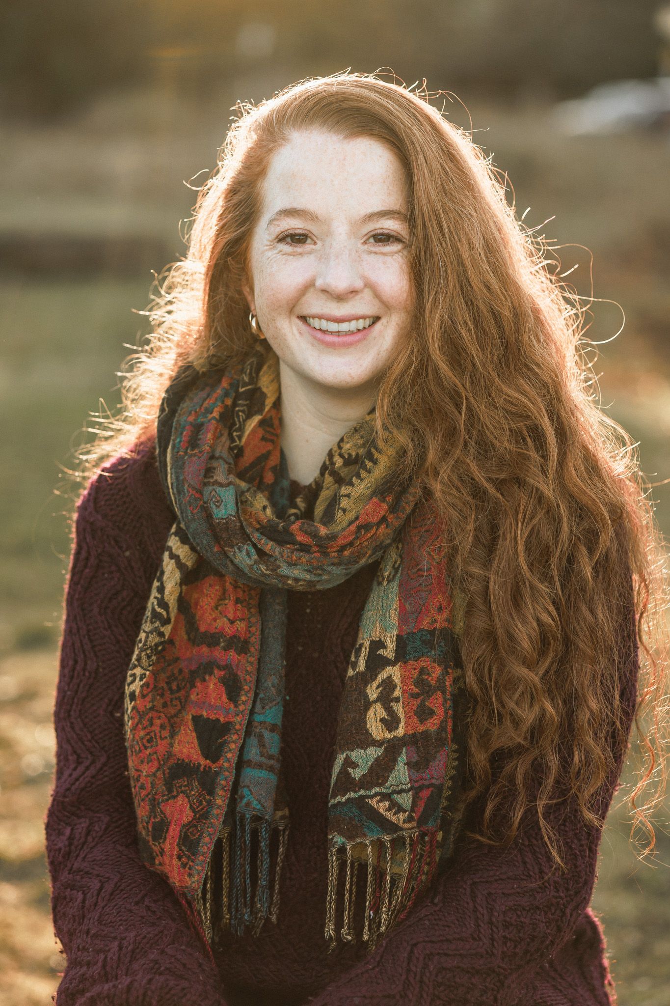 alternative headshot photo of a woman in nature surrounded by sunlight