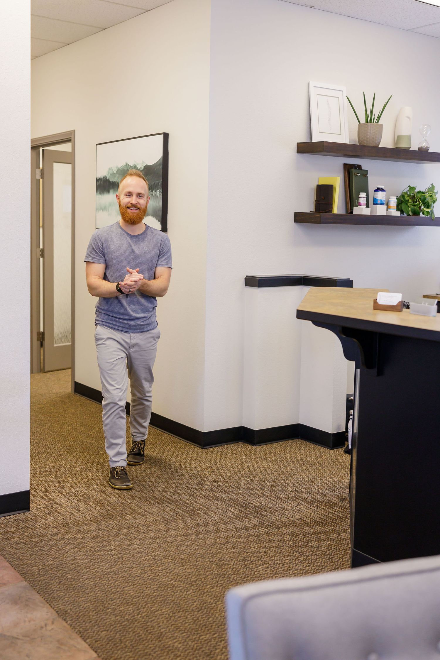 chiropractor branding photo in Sumner, WA wellness health man greet client in waiting lobby with smile on face