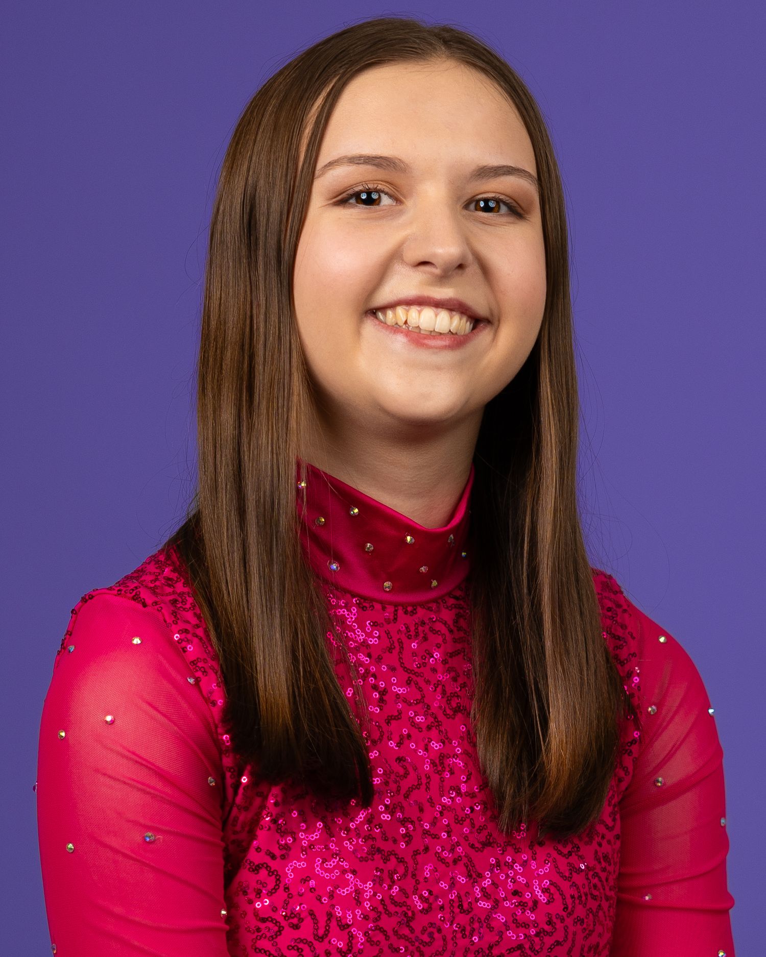 Portrait against purple background wearing sparkly pink performance attire.