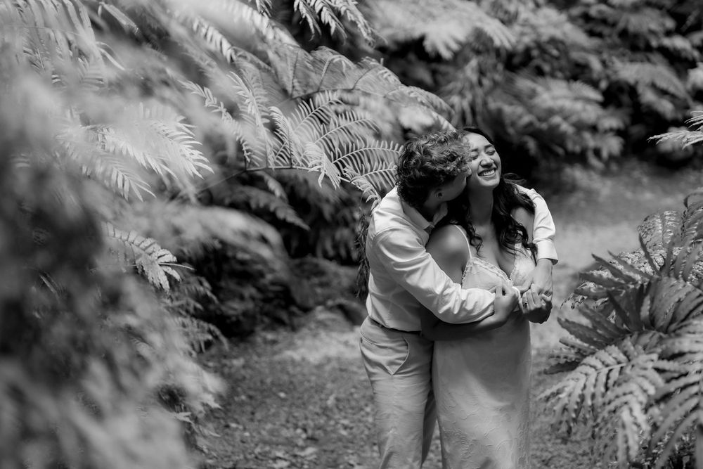 Black and white intimate portrait among ferns in a garden setting.