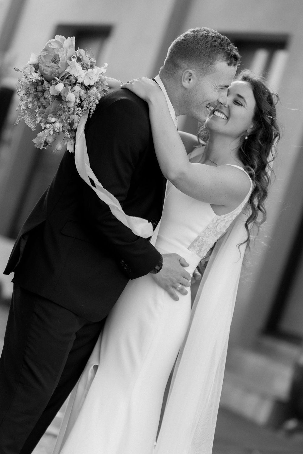 A romantic black and white wedding dance sequence showing a couple in elegant attire moving gracefully together.