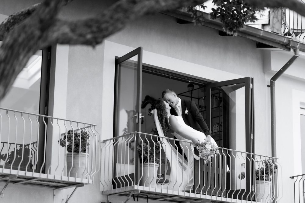 Black and white photograph of a residential building exterior with balconies and railings in an architectural style.