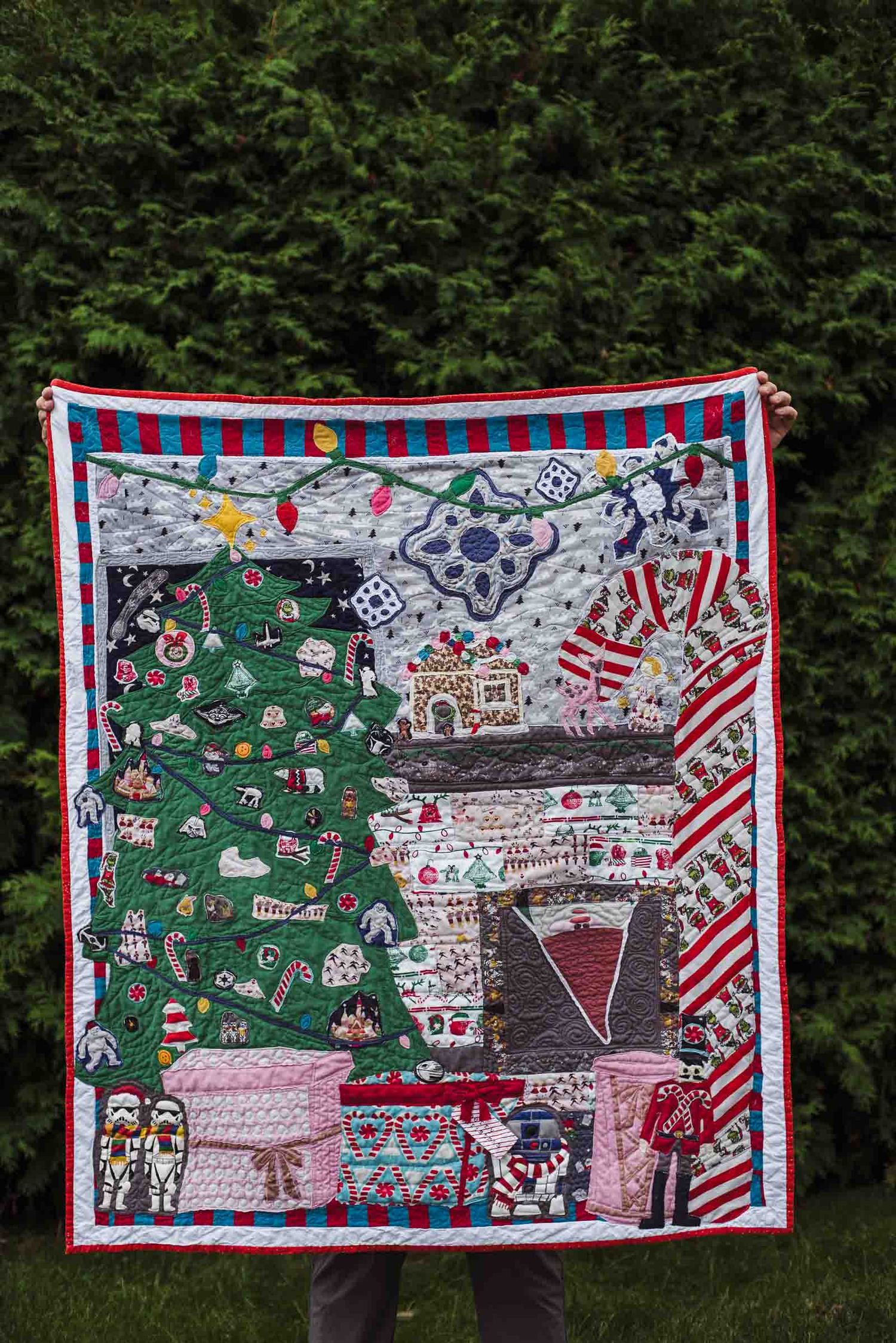Memory quilt with a Christmas tree, fireplace with a gnome sticking out and a giant candy cane made with children's pjs.
