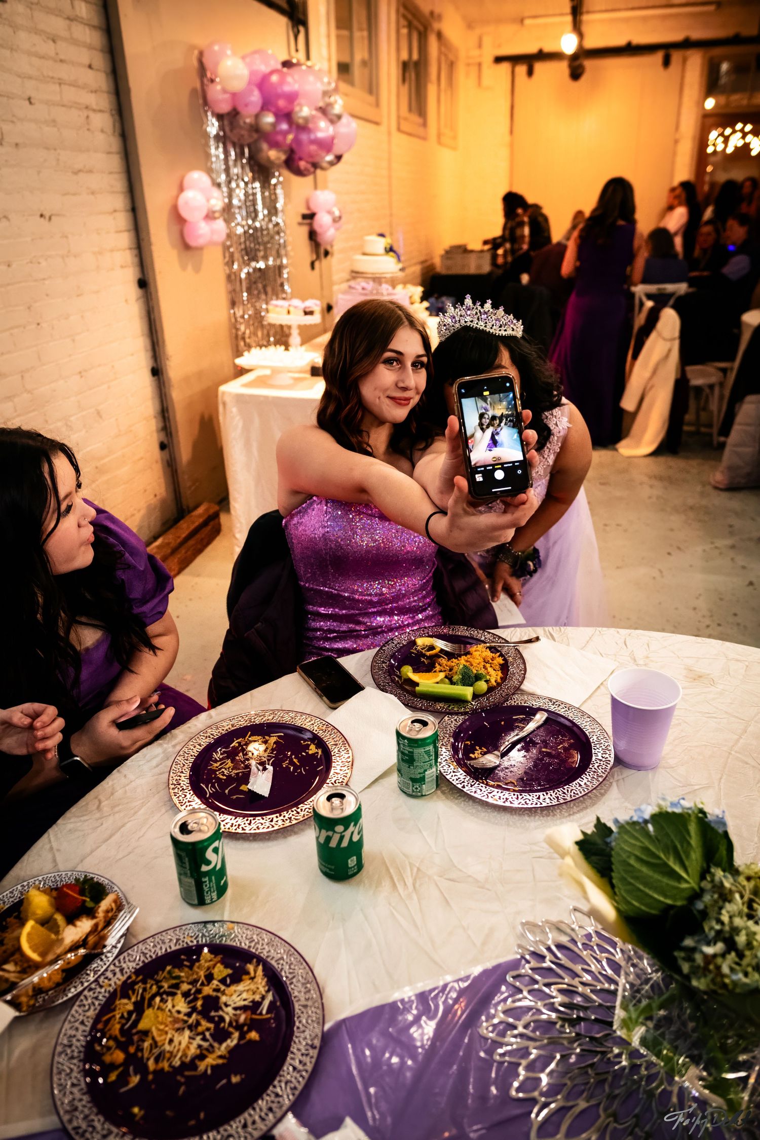 Guests at formal dinner party with purple decor and place settings.