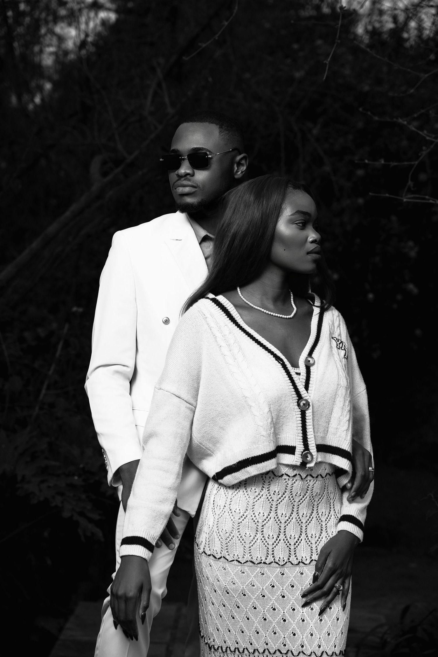Elegant black and white fashion portrait featuring coordinated white outfits.