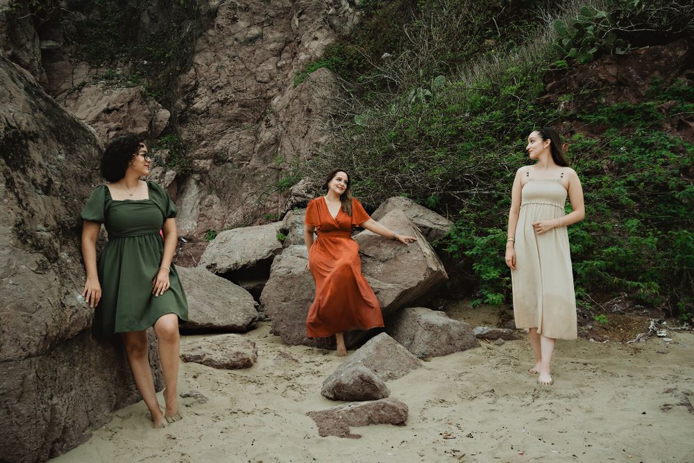 Family of three looking at each other, different poses, rock background
