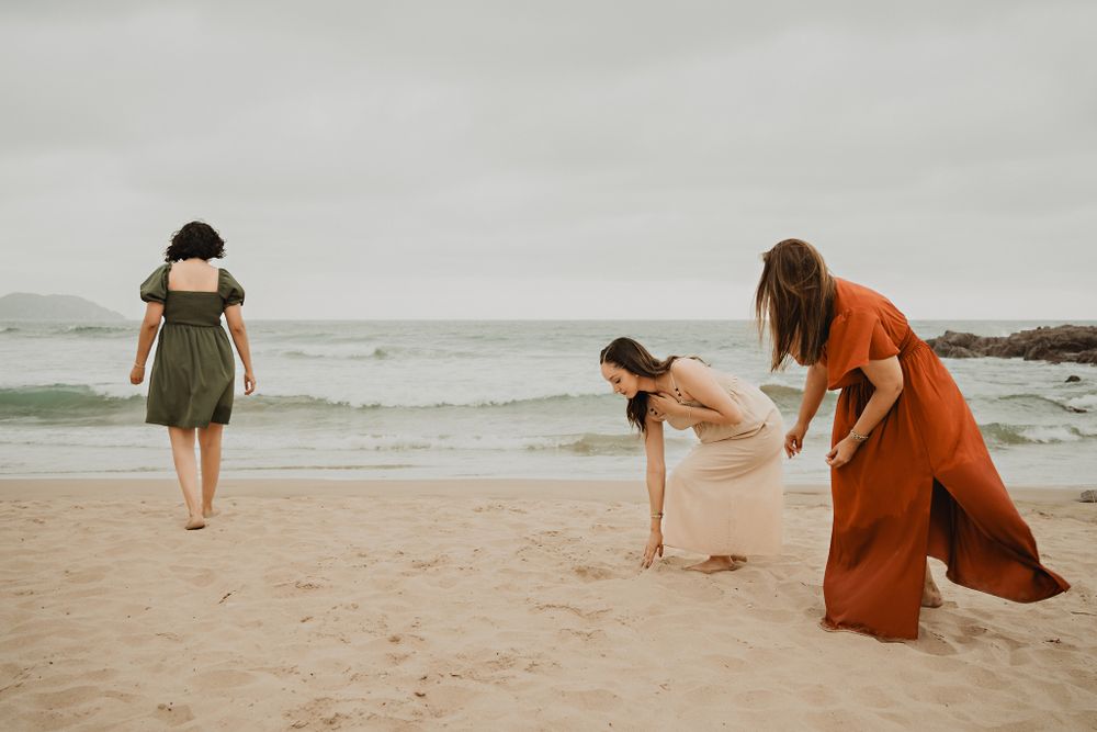 Mother and daughters searching for seashells on the beach