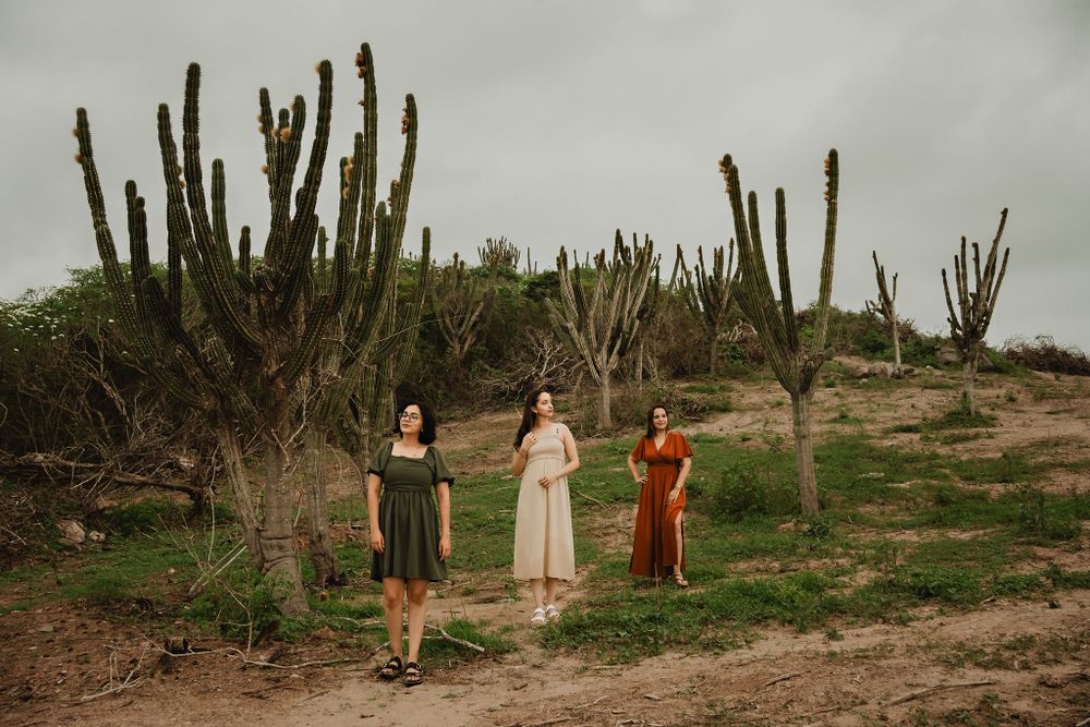Mother and daughters standing together, desert-like background, cloudy day