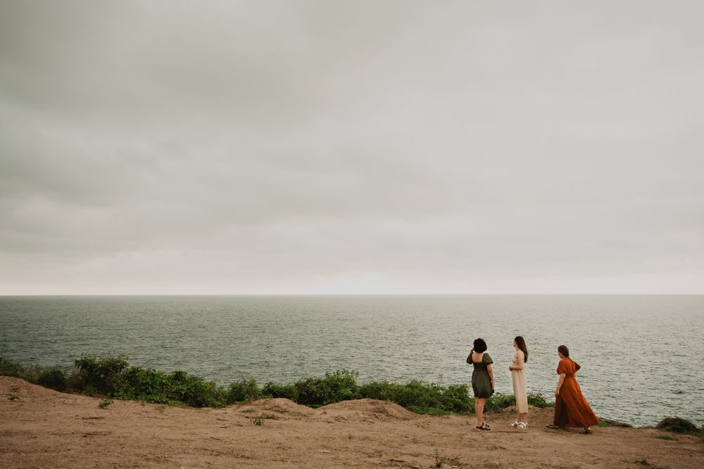 The three watching the ocean from a cliff, peaceful and cloudy day