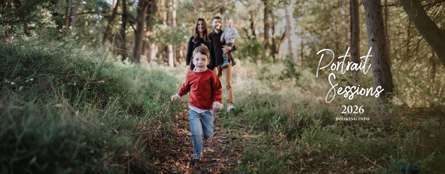 Family embraces in vibrant autumn foliage with red bushes and golden light during sunset portrait session.