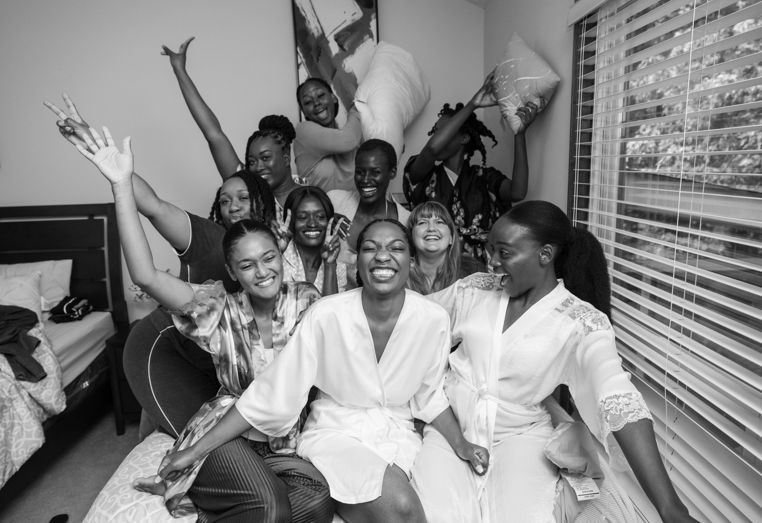 Celebratory group in matching white robes share excited moment together.