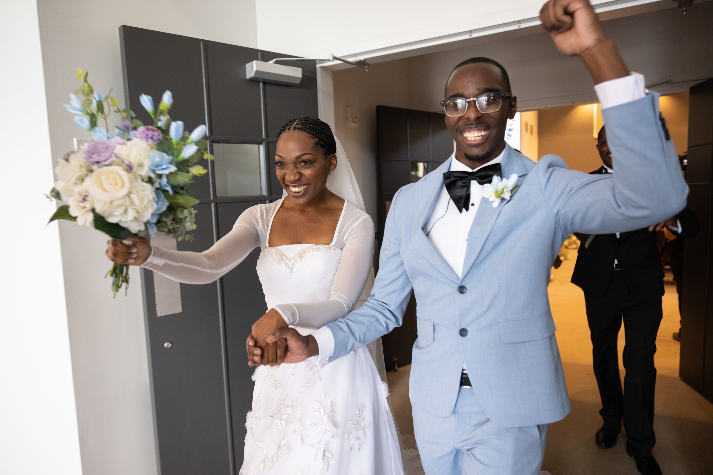A newlywed couple celebrates joyfully while exiting their ceremony.