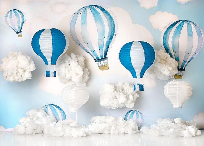 Blue and white hot air balloons floating among fluffy clouds against a light blue sky backdrop.