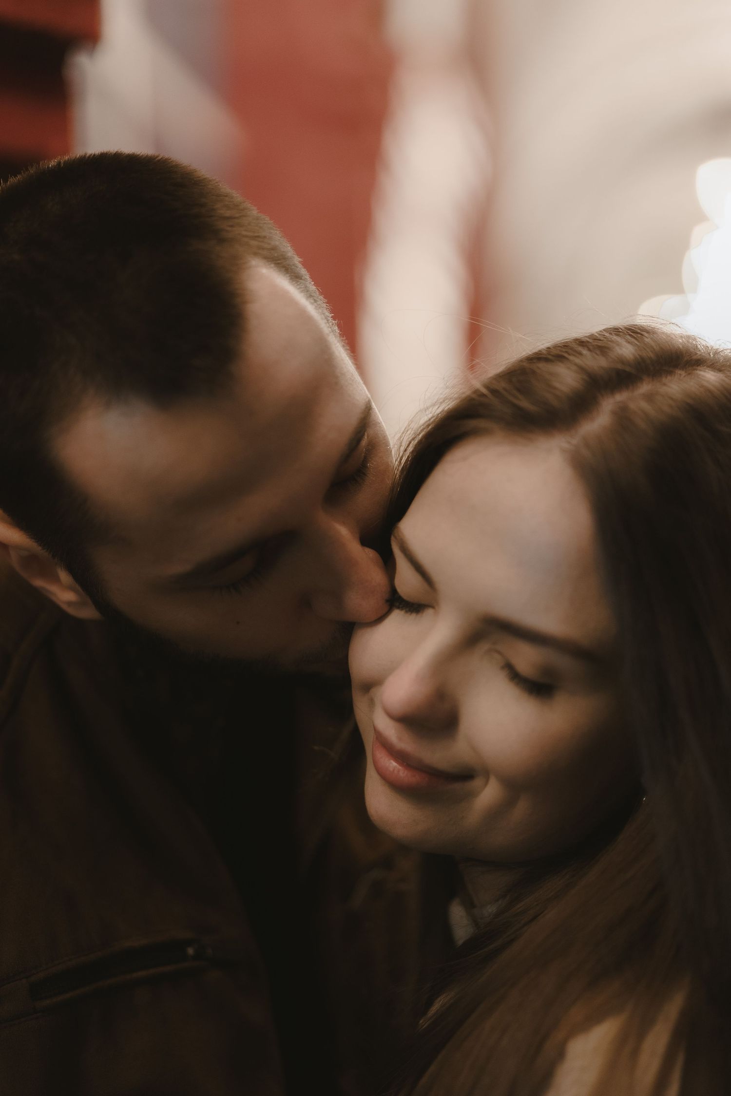 A romantic intimate moment captured in warm lighting with soft shadows and tender expressions.