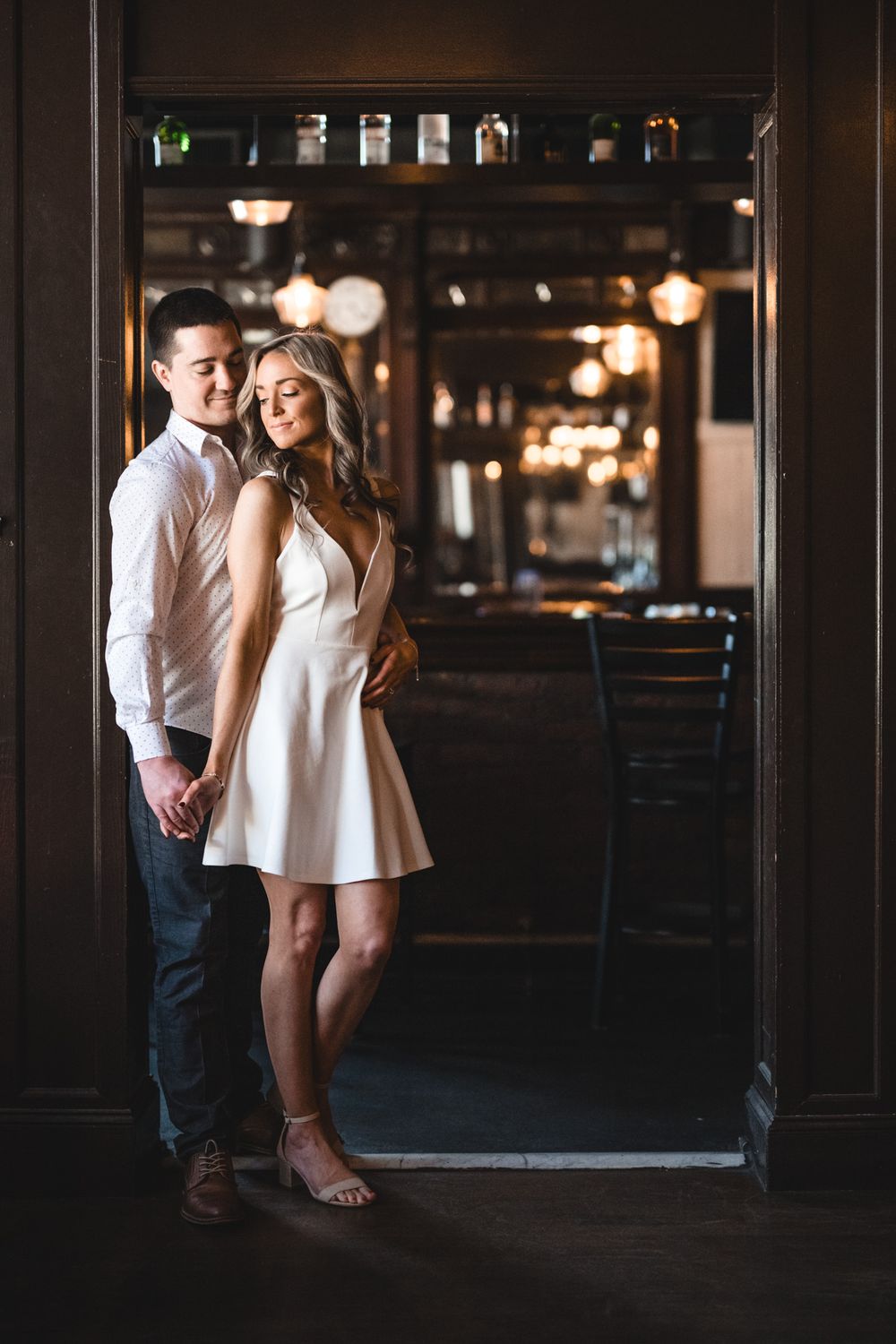 Silhouetted couple standing in dimly lit industrial space with exposed beams.