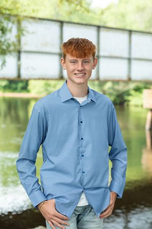 Portrait series taken by a lake with reflective water and natural lighting.