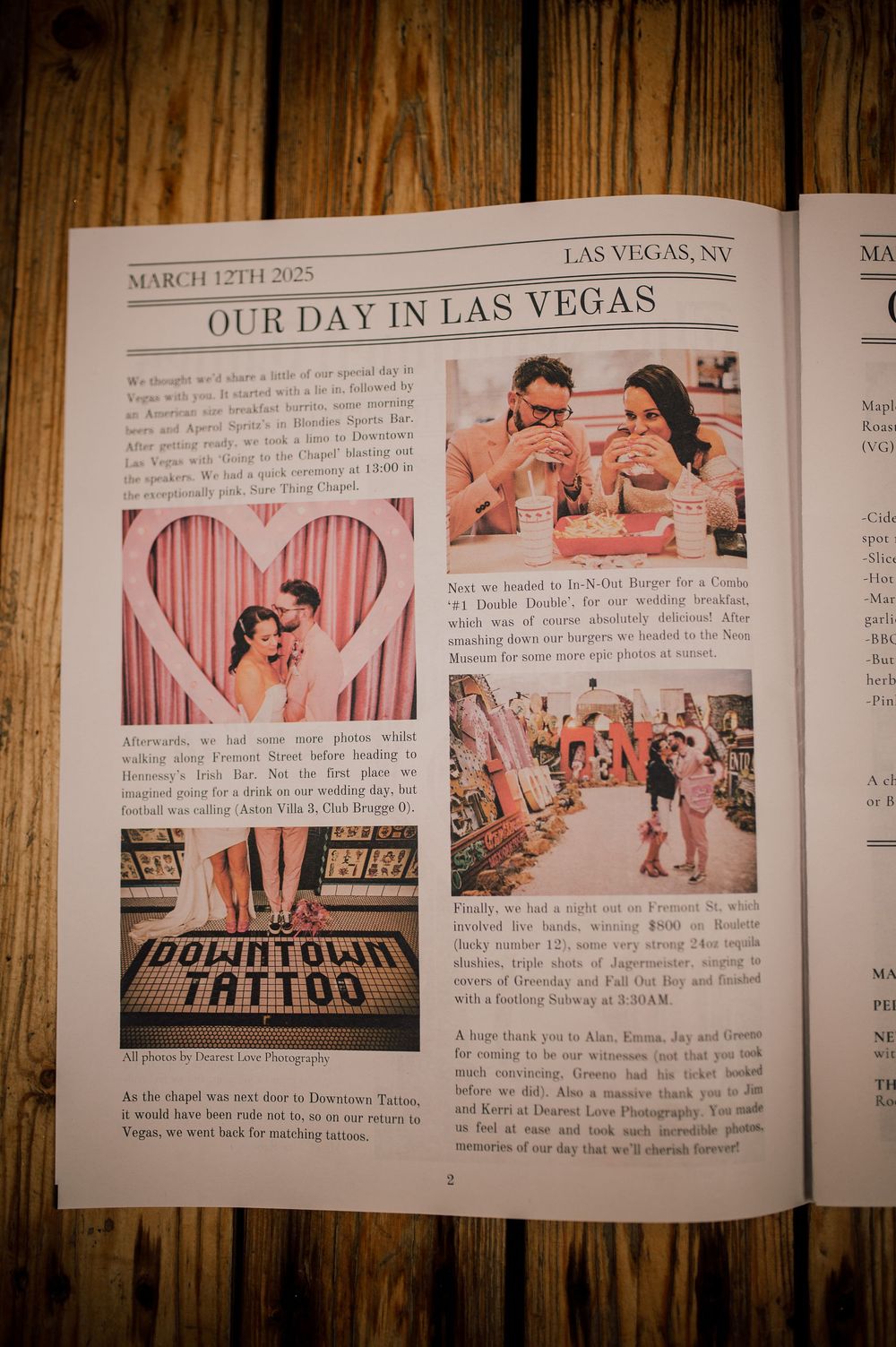 A wedding photo album spread showing pink heart decorations and Las Vegas themed photographs on wooden table.