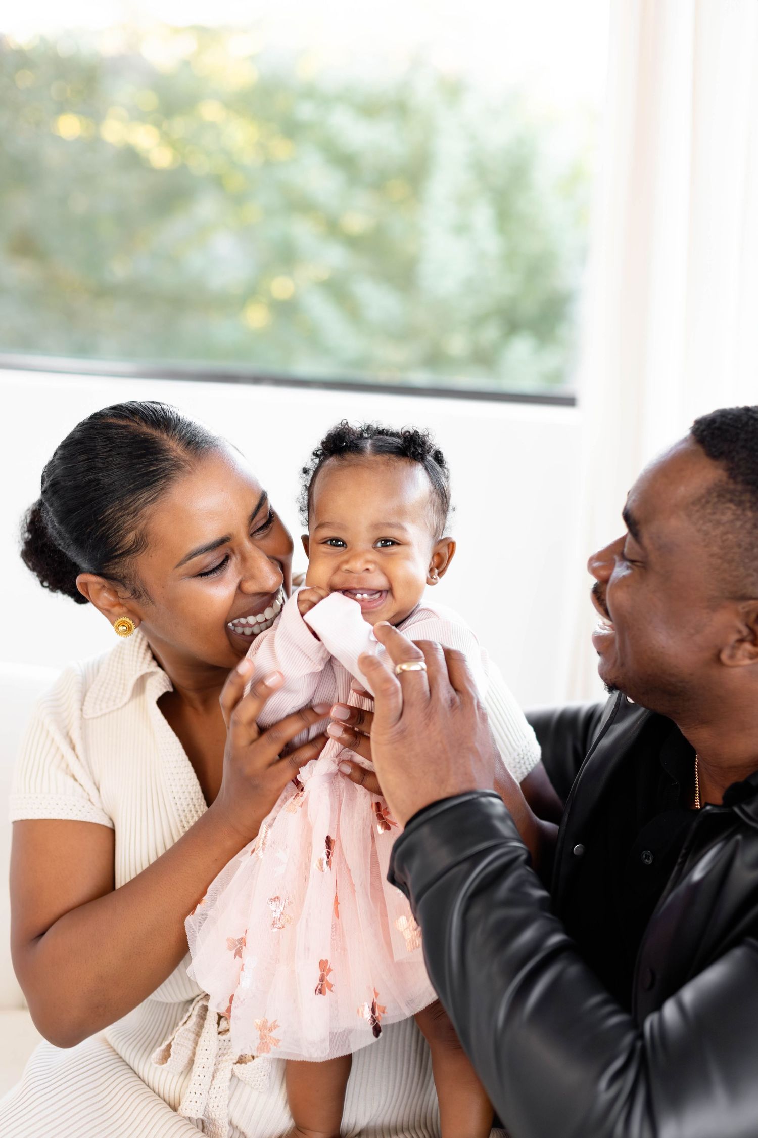 A series of four candid photos showing joyful moments between family members sharing laughter and embraces.