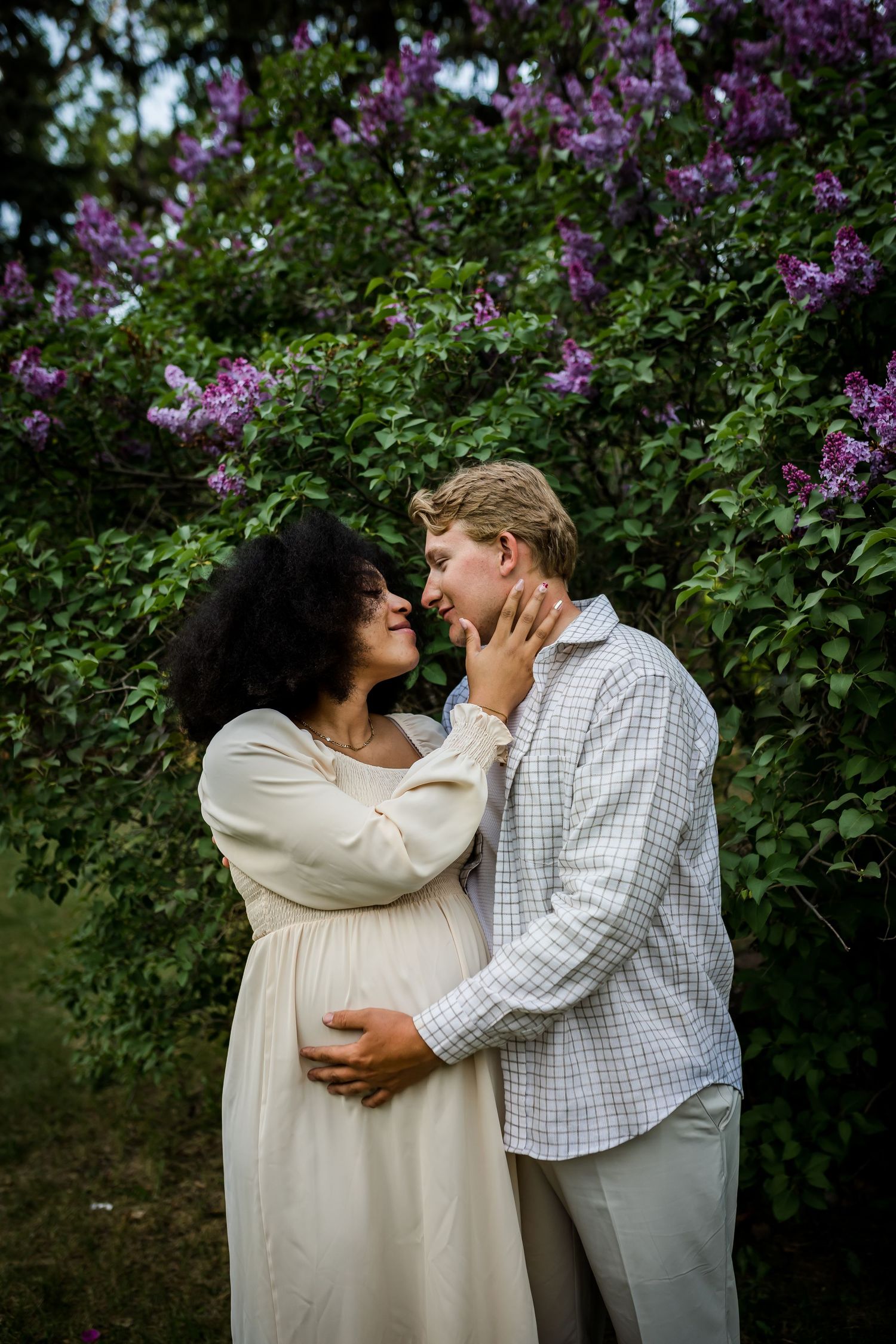 Lifestyle maternity photos in the spring flower blooms in Calgary by Love & Sunshine Photography.