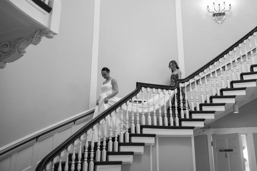 Elegant black and white curved staircase with white spindles and dark wood handrail in luxury home interior.