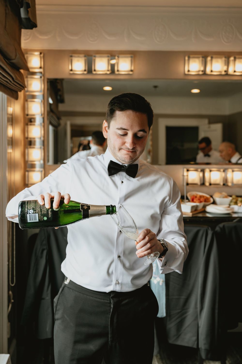 A sequence of photos showing a server in white dress shirt and bow tie pouring champagne into glasses.