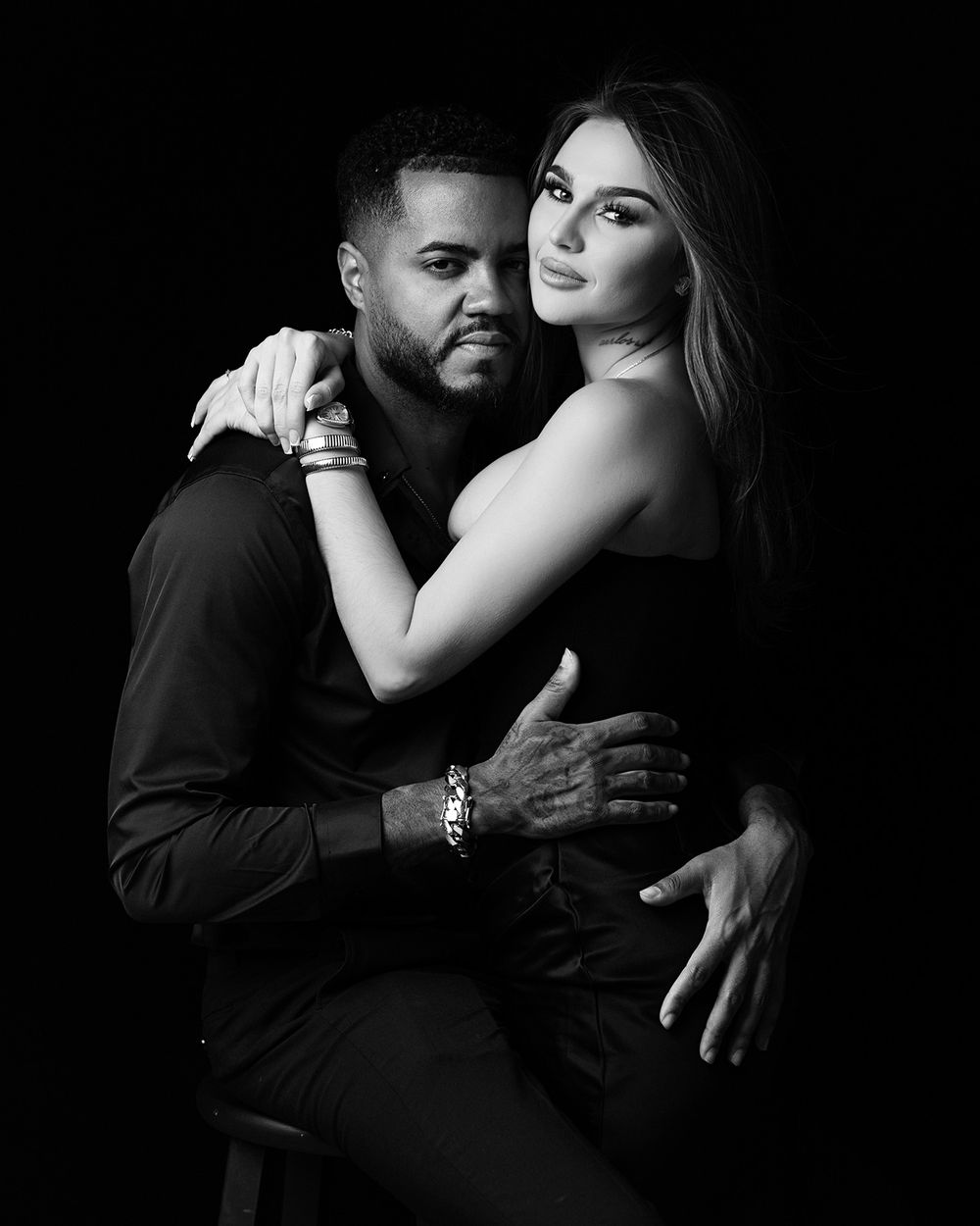 A series of intimate black and white romantic portraits showing a couple embracing in dramatic lighting.