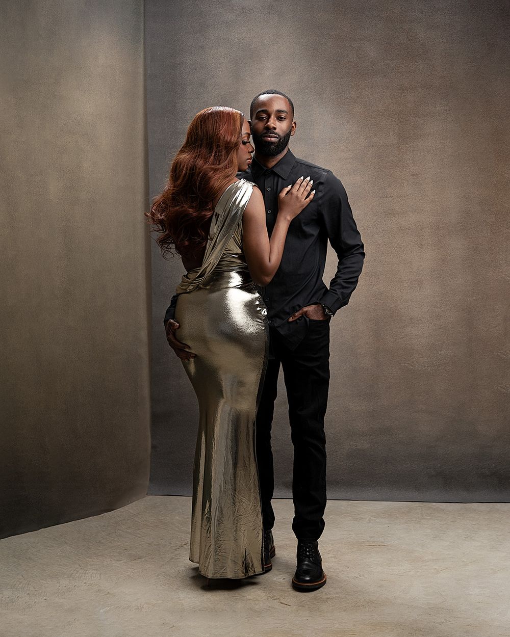 A couple in formal attire performs a romantic dance sequence against a textured gray backdrop.