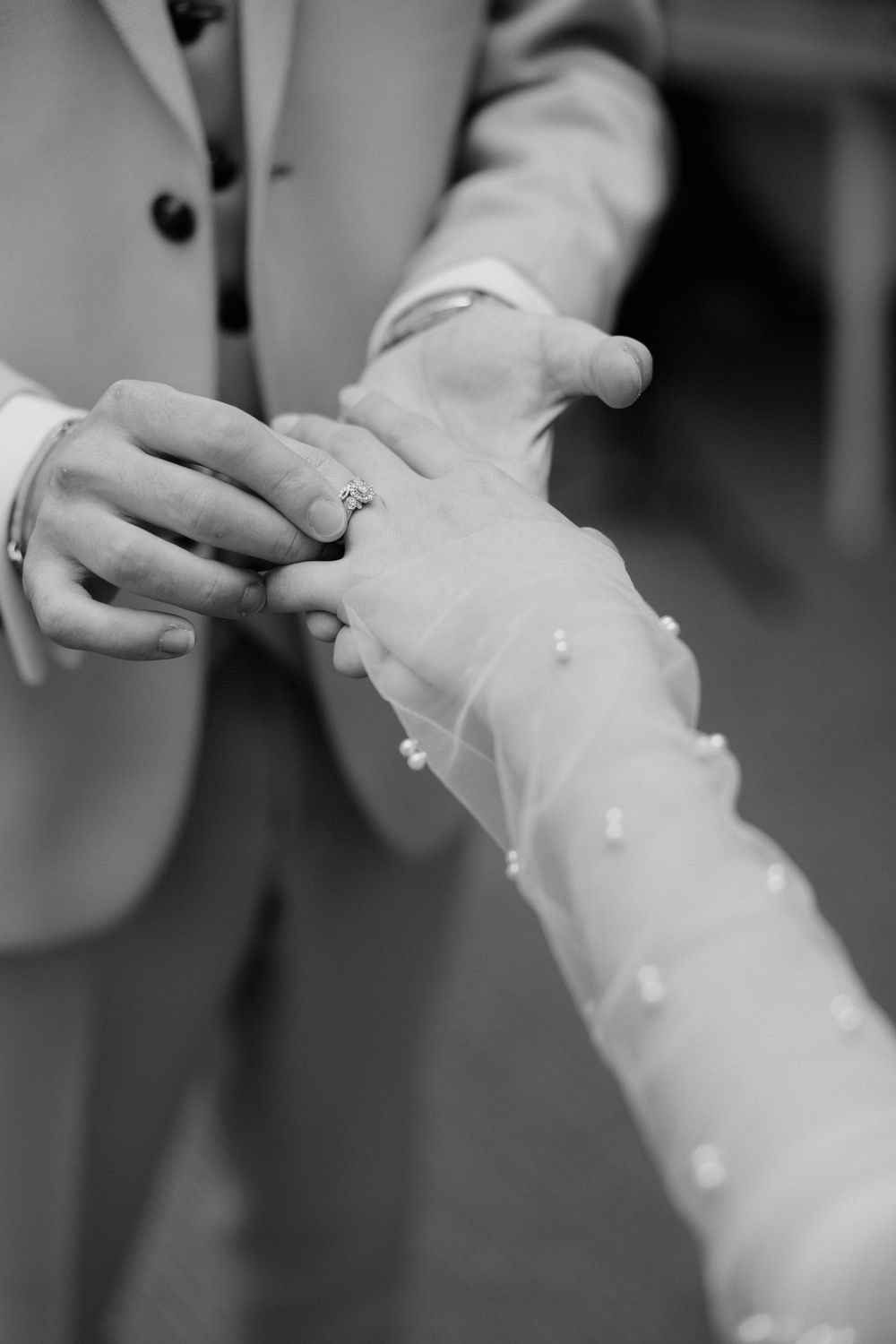 Close-up detail of delicate lace sleeves on a white wedding dress.