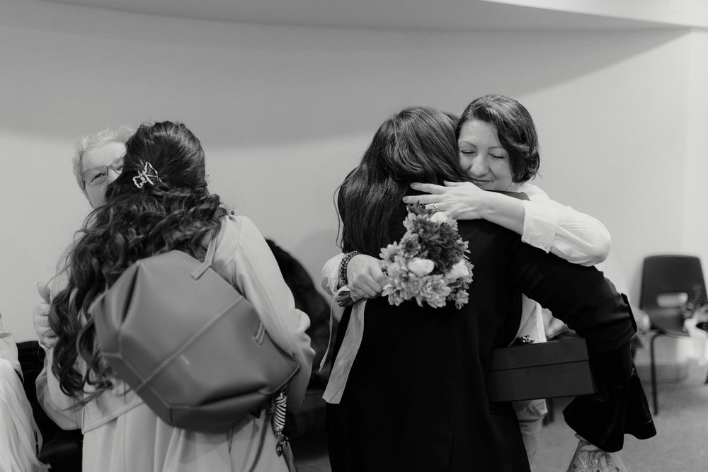 Wedding guests embrace and share emotional moments during a celebration.