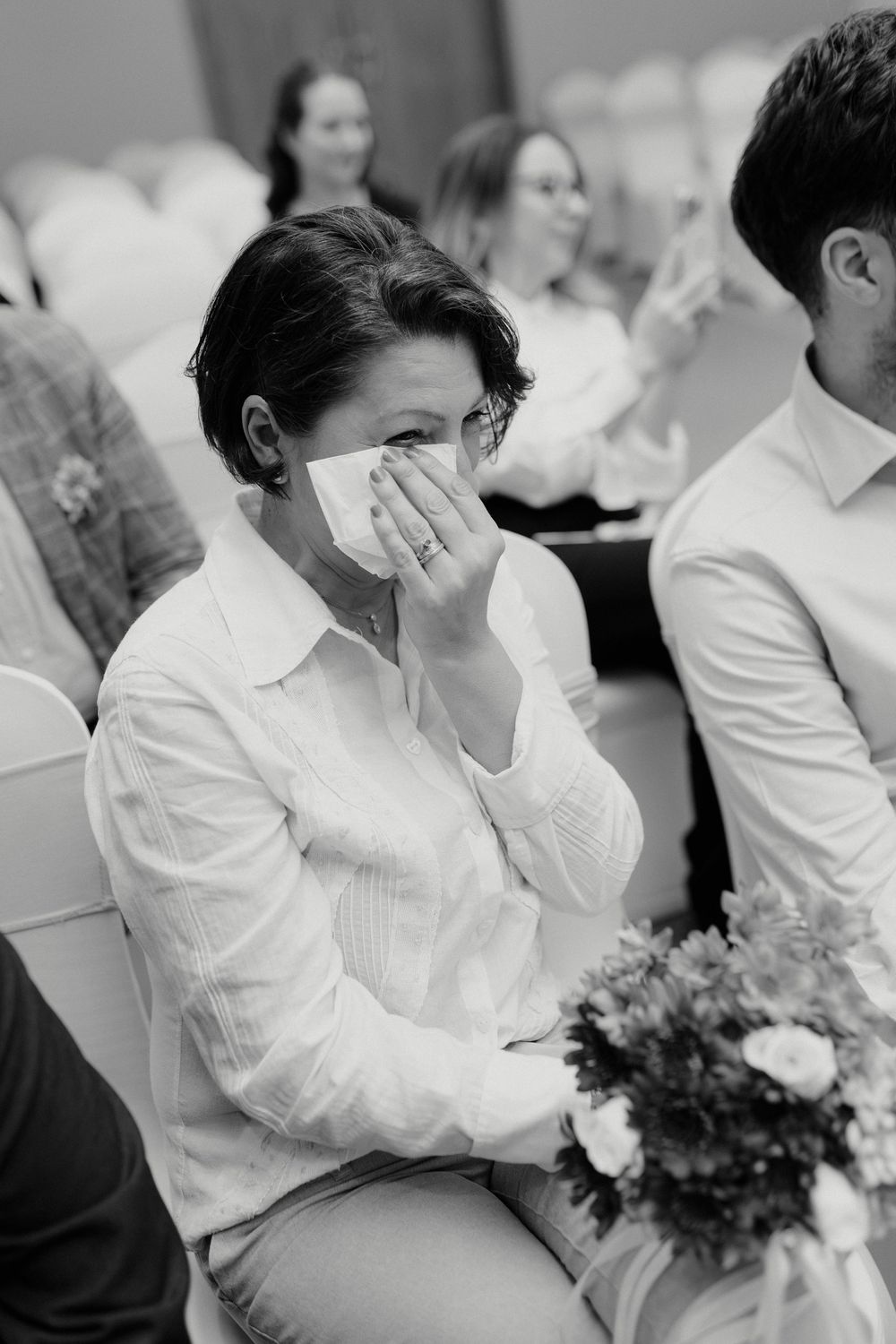 Wedding guests dressed in white seated during an intimate ceremony.