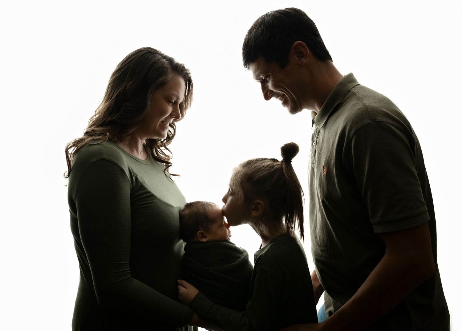 Family is backlit holding newborn boy while brother is kissing the b - Greenville, SC newborn photographer - Easley, SC newborn photographer