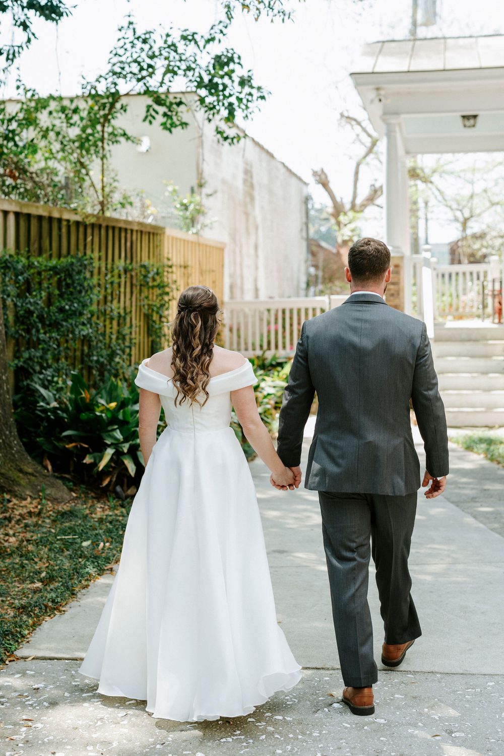 A bride and groom walk hand in hand down a sunlit path, shown from behind in a series of candid wedding photos.
