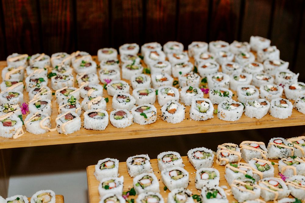 Rows of white ceramic teacups with colorful floral patterns displayed on wooden shelves in a retail setting.