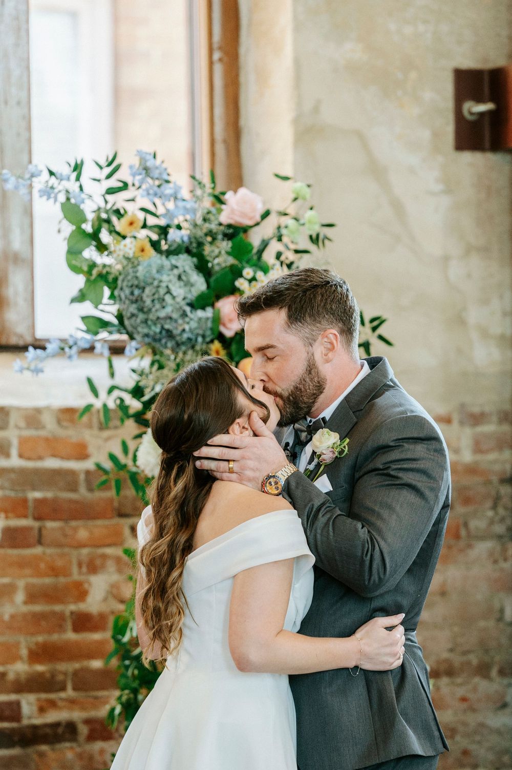 Intimate wedding moments captured in sequence against rustic brick and plaster walls with elegant floral decor.