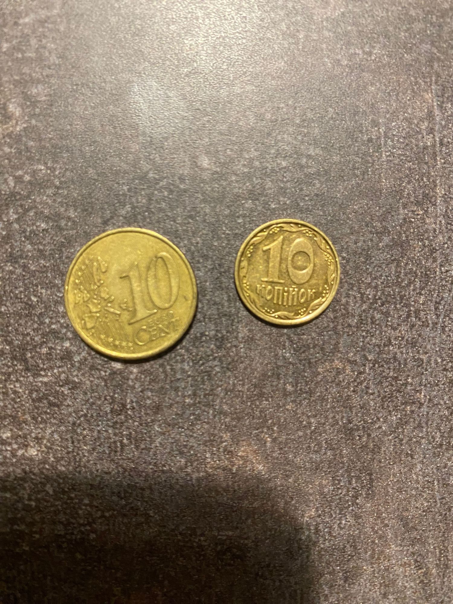 An image of two gold-colored coins, one with the number 10 and the other with the number 10, on a gray background.