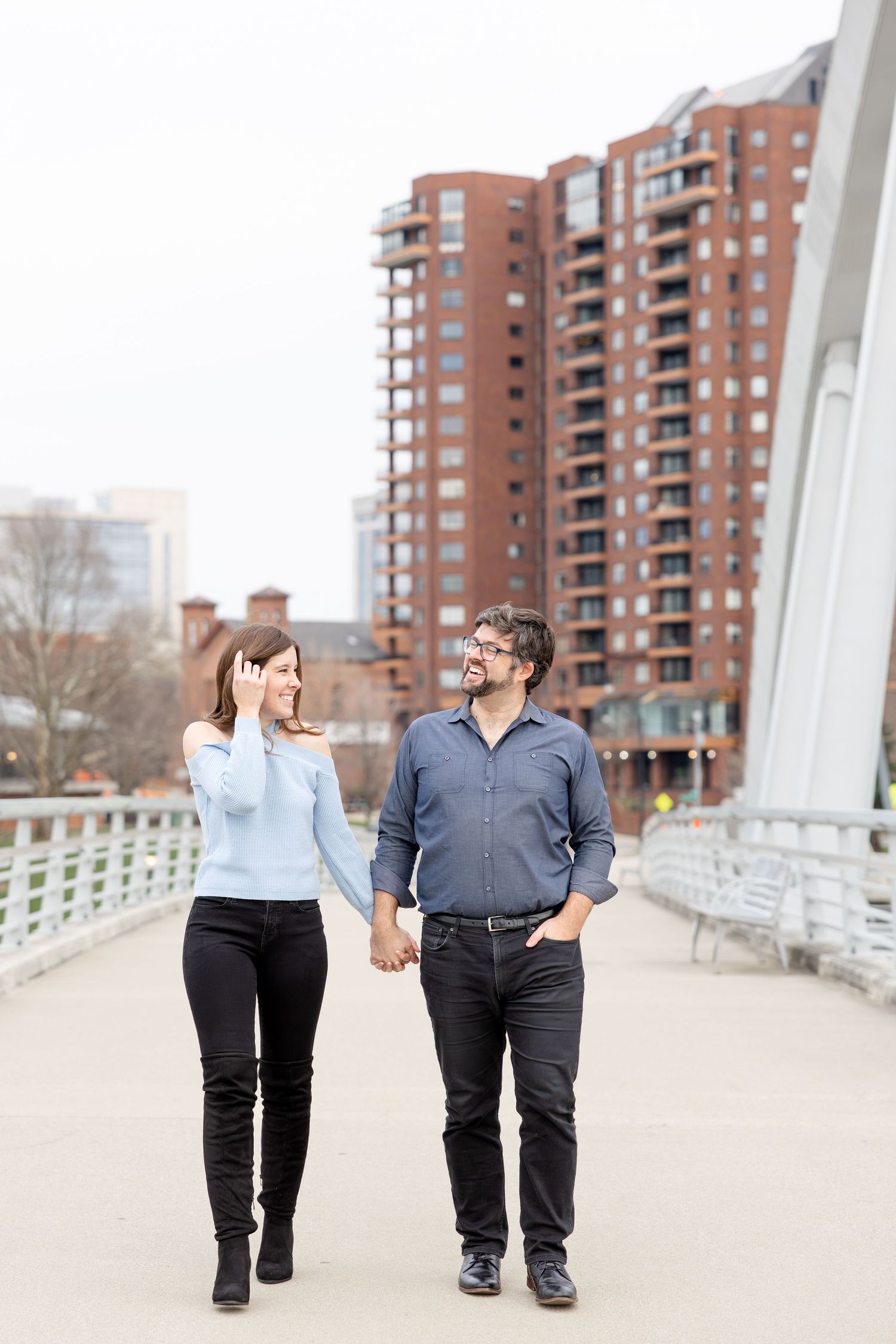 Downtown Columbus engagement photos on Main Street Bridge featuring a joyful couple with light and airy, natural movement and candid moments
