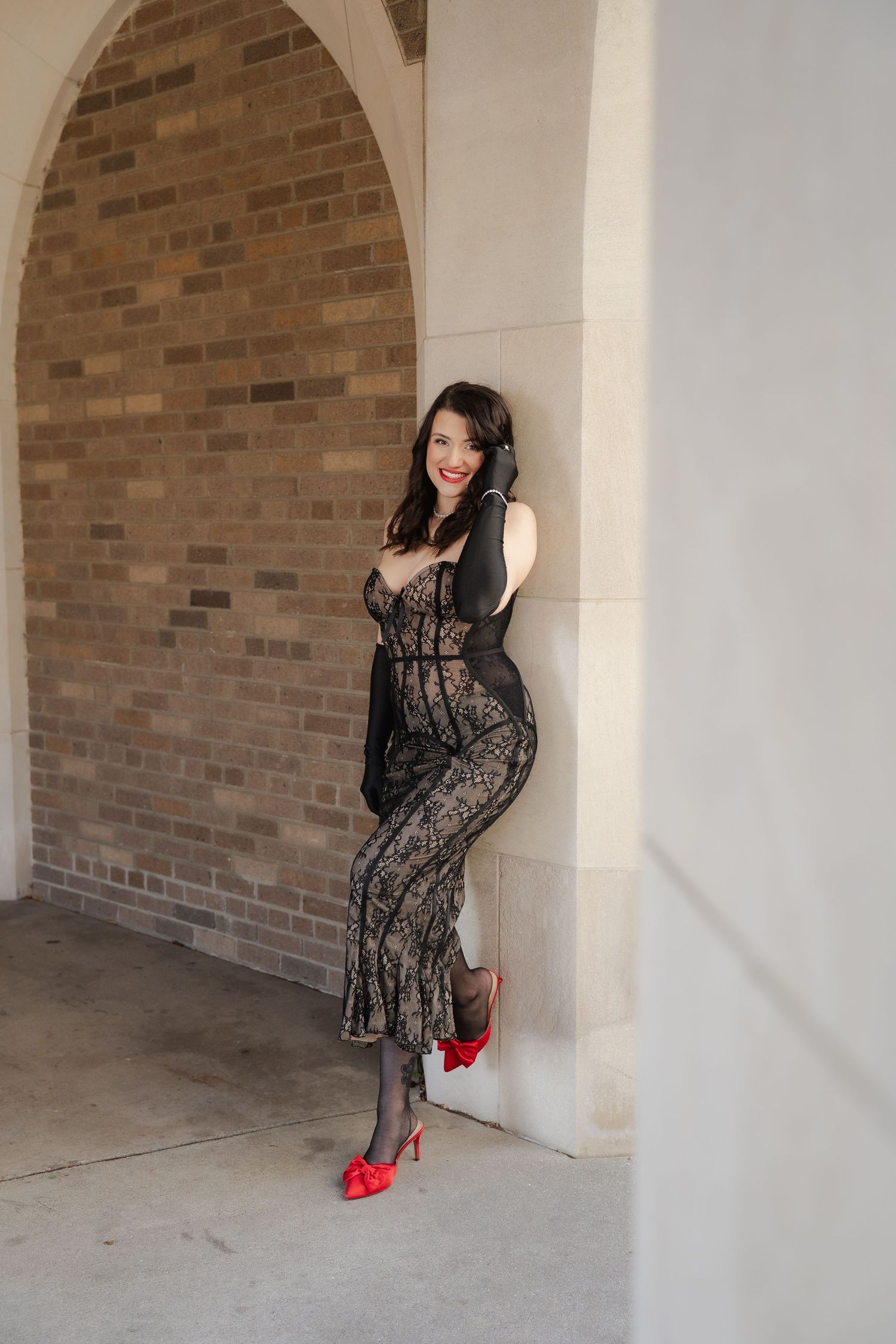 Fashion model poses in brown pinstripe outfit against white curtain background.