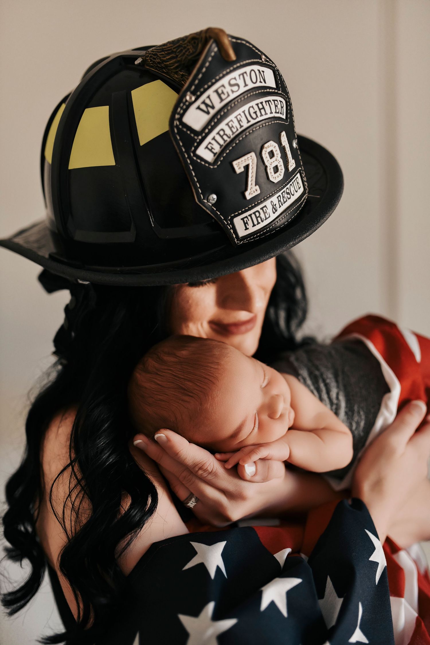 Mother kissing her newborn baby softly during a luxury studio newborn session in Denton, Texas