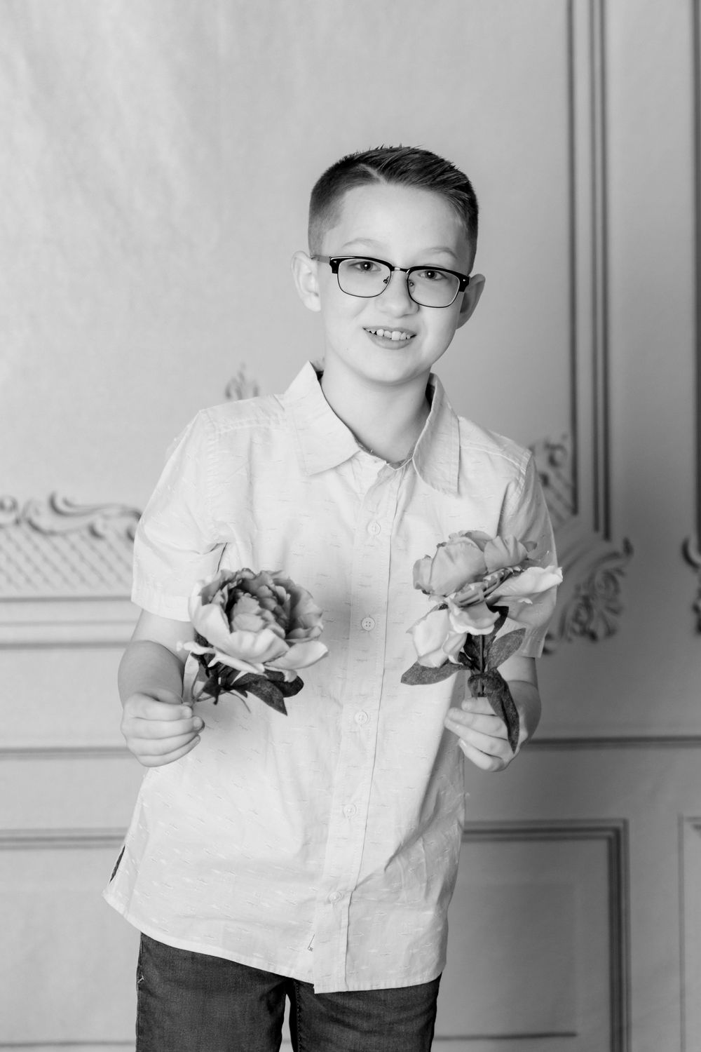 Black and white photo series of a child in white shirt holding flowers against an ornate wall with decorative molding.
