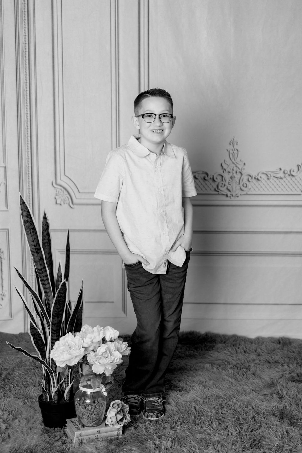 Artistic black and white portrait series showing figure with plants and decorative wall panels.
